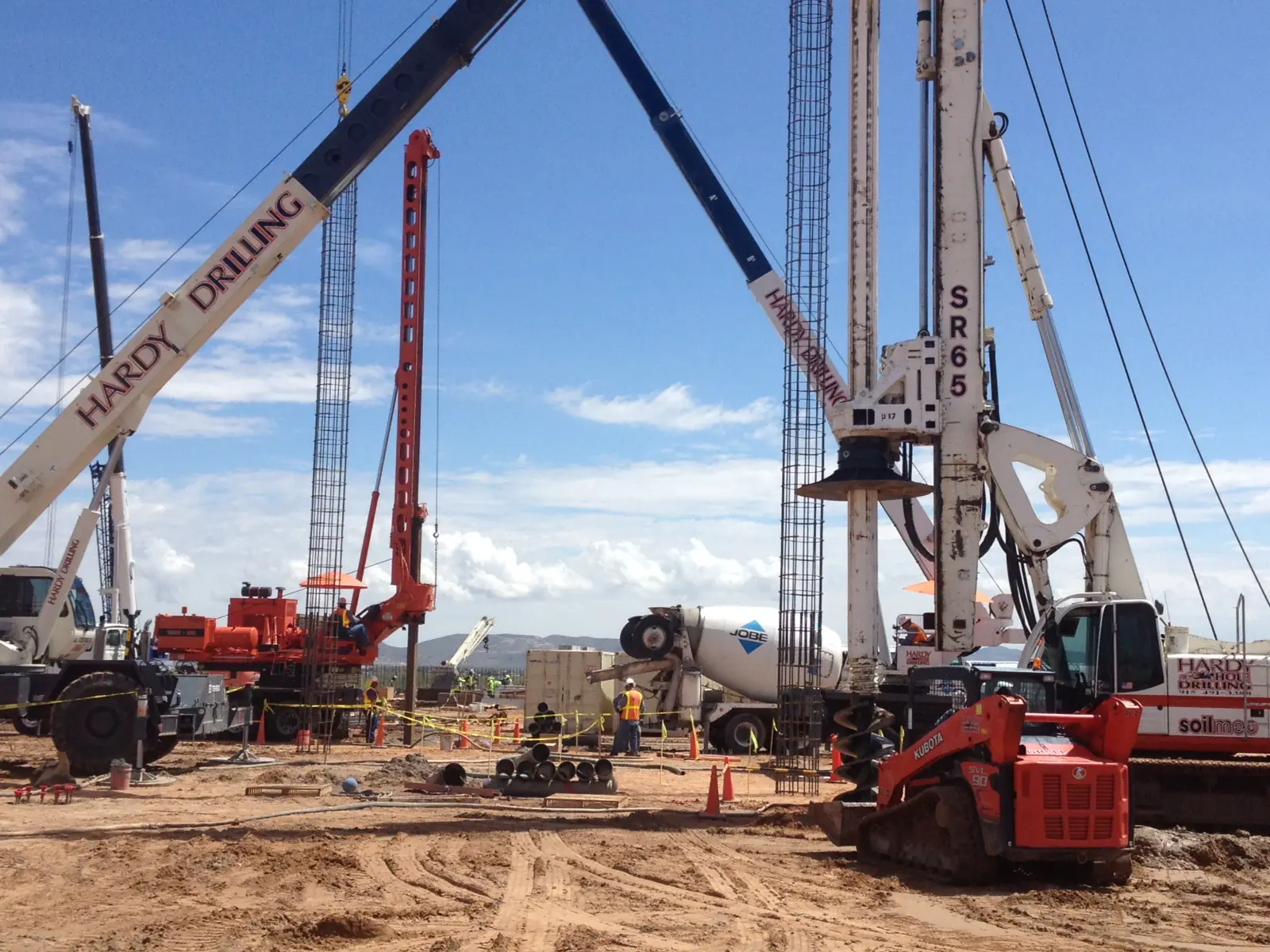 Heavy machinery operating at a construction site under a clear sky.
