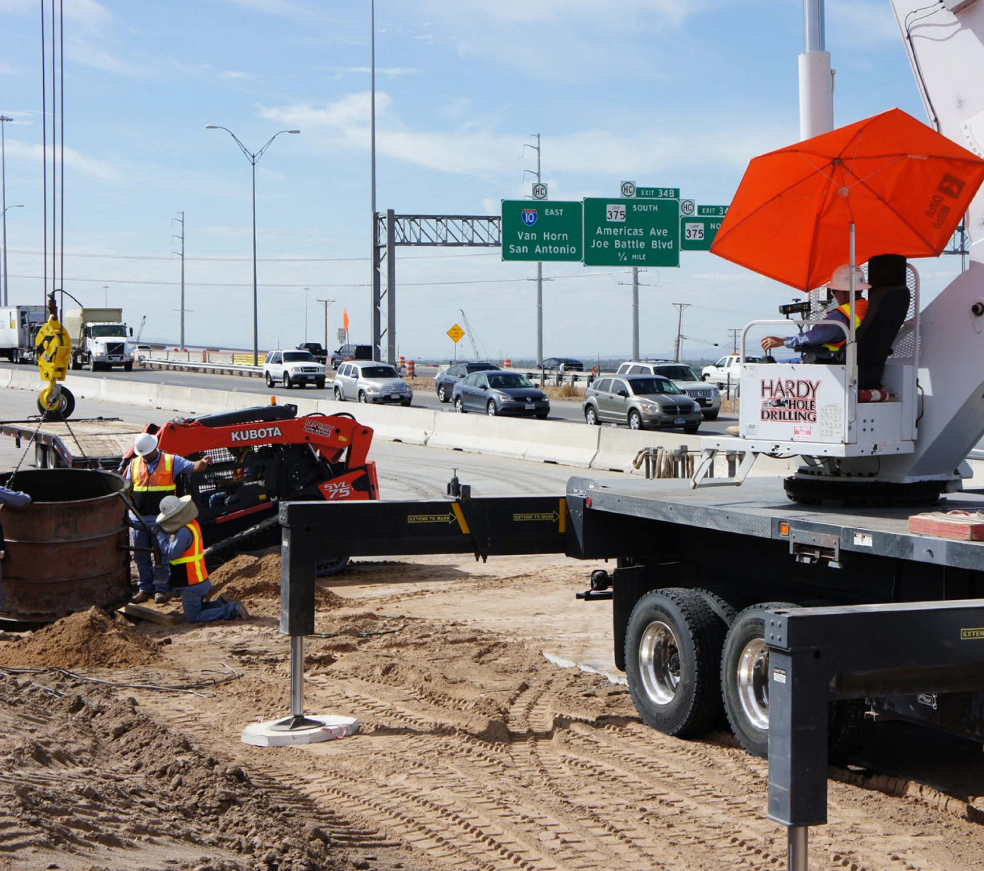 Workers drilling near busy highway